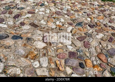 Old cobblestone pavement on the road as creative background texture Stock Photo