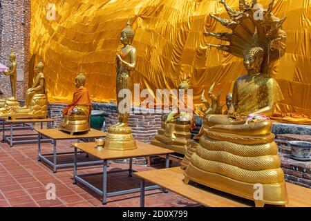 AYUTTHAYA, THAILAND, JUN 03 2020, The golden statues of Buddha under the reclining Buddha covered with the golden fabric, Wat Khun Inthapramun. Stock Photo