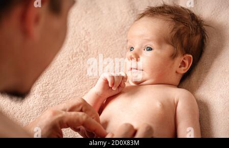 The baby boy looks at dad in surprise. Selective soft focus Stock Photo