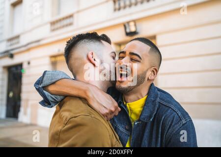 Portrait of happy gay couple spending time together and hugging in the street. Lgbt and love concept. Stock Photo