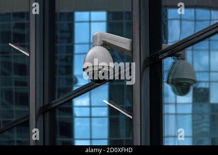 surveillance camera on glass office building Stock Photo