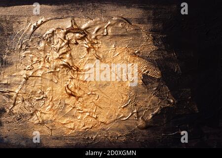 Golden bright paint smudges frozen on a dark blue palette for drawing with dried layers of paint. Stock Photo