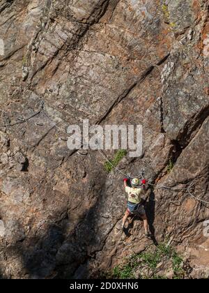 Man, aged 80+, climbs on the Ouray Via Ferrata, Ouray, Colorado. Stock Photo