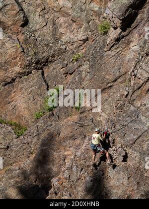 Man, aged 80+, climbs on the Ouray Via Ferrata, Ouray, Colorado. Stock Photo