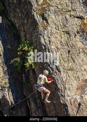 Man, aged 80+, climbs on the Ouray Via Ferrata, Ouray, Colorado. Stock Photo