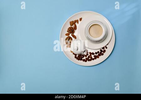 Raisins and walnuts in a large white ceramic tray plate, and sugar. On a blue background.  Stock Photo