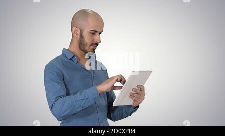Handsome arabic business man using tablet on gradient background Stock Photo