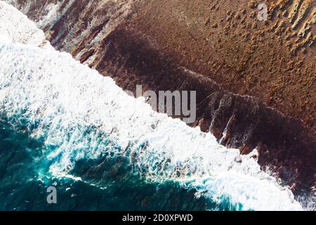 Majestic arial drone view of dark tropical beach and breaking ocean waves. Blue water background. Nature of Bali, Indonesia. High quality Stock Photo