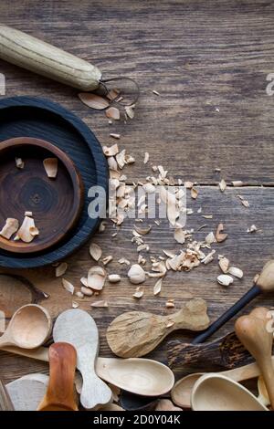 Handmade wooden kitchen utensils, top view lot of billets, spoons and plates on wooden table, selective focus Stock Photo