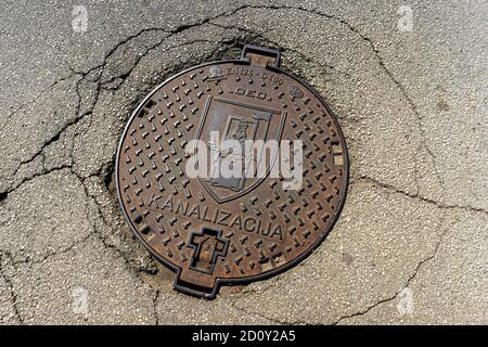 Manhole, sewer cover on the old street Stock Photo