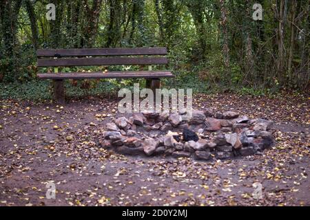 Stone fireplace photographed with a wooden bench in nature. Stock Photo