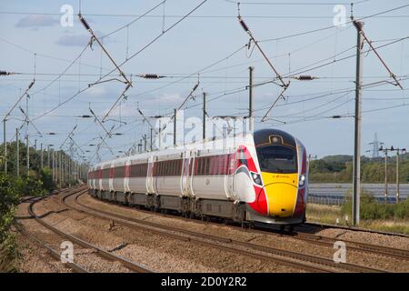 A Class 801 Azuma electro-diesel multiple unit number 801230 working an LNER service along the East Coast Mainline at Sandy. Stock Photo