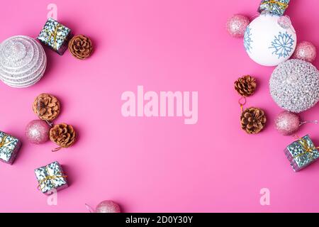 Christmas New Year composition. Gifts, fir tree cones, silver ball decorations on pink background. Winter holidays concept. Flat lay, top view Stock Photo