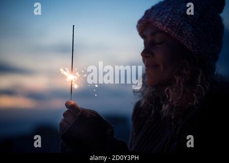 Celebration and hope future concept with beautiful woman portrait with fired sparkler in the dark of the night around - new year eve and celebration i Stock Photo