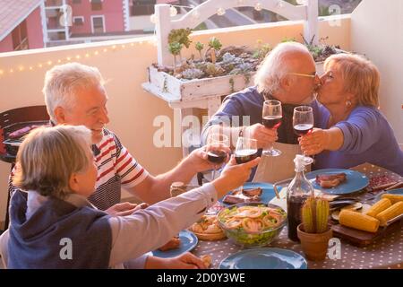 Group of happy senior old people have fun together during lunch or dinner at home in outdoor terrace - alderly lifestyle couple celebrating with frien Stock Photo