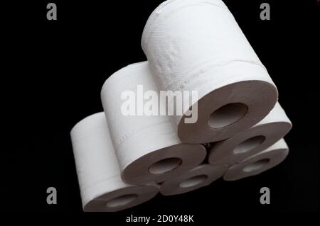 Rolls of toilet paper isolated on black background in close-up. Copy space. Horizontal shot. Stock Photo