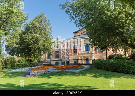 The Bayreuth Festspielhaus peeking through the trees, in front of the theatre Stock Photo