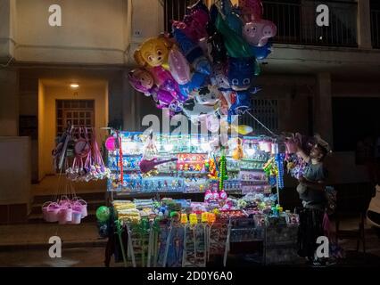 cheap plastic toys, American superheroes from the Marvel universe as plastic figures on a sales cart and helium filled balloons during summer Fiesta in the village of Altea La Vella, Spain on 27.72019 Stock Photo