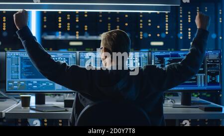 IT Specialist Working on Personal Computer with Monitors Showing Coding Language Program, He Celebrates His Success by Doing YES Gesture. Technical Stock Photo