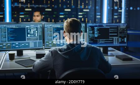 IT Specialist Works on Personal Computer with Screens Showing Software Program with Coding Language Interface. In the Background Technical Room of Stock Photo