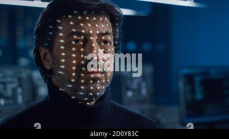 Biometric Facial Recognition Scanning Proccess. Man Getting Identified by Hardware Scanning Facial Feautures with Light. Futuristic Concept Shot in Stock Photo