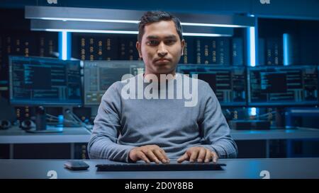 Portrait of Software Programmer Sitting at His Desk and Working on Computer in Digital Identity Cyber Security Data Center. Hacking or Programming Stock Photo