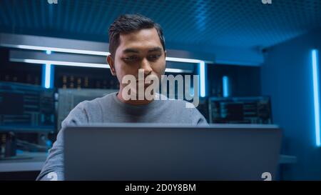 Portrait of Software Programmer Sitting at His Desk and Working on Computer in Digital Identity Cyber Security Data Center. Hacking or Programming. Stock Photo
