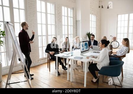 Confident male coach present business project at team meeting Stock Photo