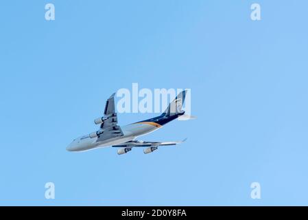 Looking up at a UPS 747 air freight jet airline plane bringing air cargo into Sydney Australia on a clear skies sunny day Stock Photo