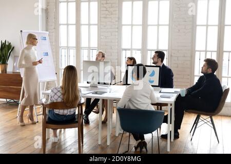 Caucasian female speaker make flip chart presentation at briefing Stock Photo