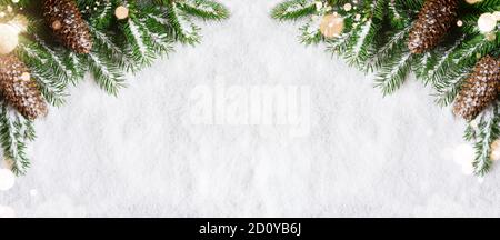 Christmas background, green pine branches, cones on snow background and light. Creative composition with border and copy space, top view. New Year's, Stock Photo