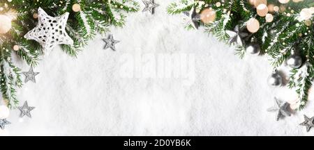 Christmas background, green pine branches, cones on snow background and light. Creative composition with border and copy space, top view. New Year's, Stock Photo