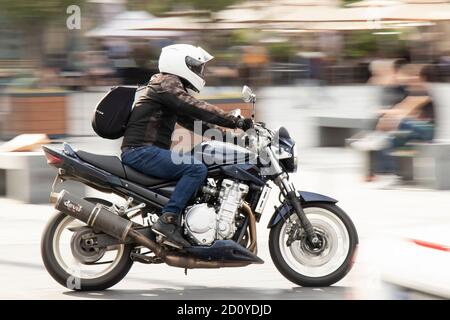 Belgrade, Serbia - October 02, 2020: Man riding a fast motorbike on the street by city square, panning shot Stock Photo