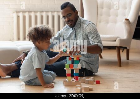 Caring affectionate young african american daddy playing with son. Stock Photo