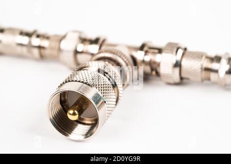 Microwave coaxial adapter UHF Male To N Female connector. Concept of radio details. High frequency component with a metallic covering on white backgro Stock Photo