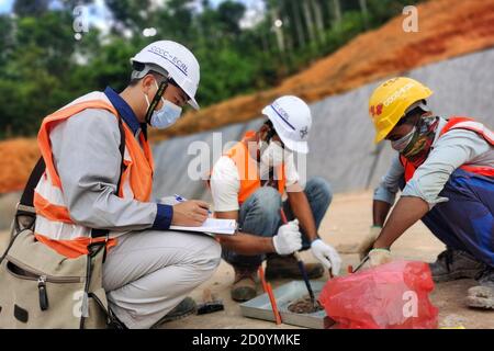 Kuala Lumpur, Malaysia. 30th Sep, 2020. Liu Zhixin (L), a 25-year-old technician of China Communications Construction Company (CCCC), works with his local colleagues at the construction site of the East Coast Rail Link (ECRL) rail project in Paka, Terengganu, Malaysia, Sept. 30, 2020. TO GO WITH 'Feature: Young Chinese technician spends first oversea Mid-Autumn Festival at site of Malaysia's ECRL rail project' Credit: Ye Huiyuan/Xinhua/Alamy Live News Stock Photo