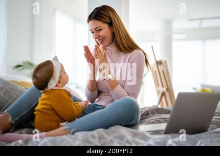 Mother and baby daughter plays, hugging, kissing at home. Happy family. Stock Photo