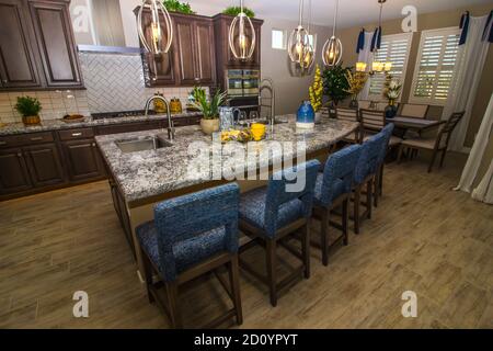 Granite Kitchen Island With Counter Bar Stools And Separate Dining Area Stock Photo