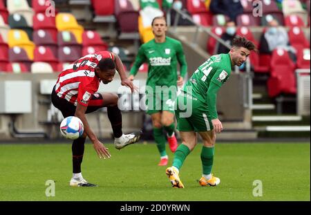 Brentford's Ethan Pinnock (left) and Preston North End's Sean Maguire battle for the ball during the Sky Bet Championship match at the Brentford Community Stadium, London. Stock Photo