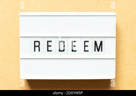Lightbox with word redeem on wood background Stock Photo