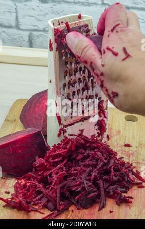 grate beetroot on a grater, fresh beet grated Stock Photo