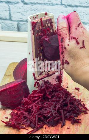 grate beetroot on a grater, fresh beet grated Stock Photo