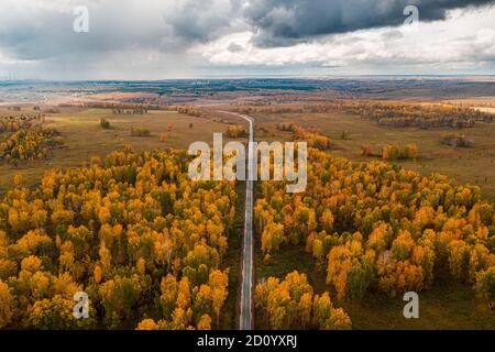 Aerial view on railway under construction, among forests, fields and villages. Road works in the forest and in fields. Dirt road in an open area Stock Photo