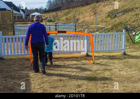 Stay at home. Outdoor games. Grandma with grandson playing football on backyard. Covid-19. Stock Photo