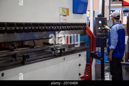 Industrial professional operating CNC synchronize hydraulic press brake bending machine. Industrial metalwork machinery. Stock Photo