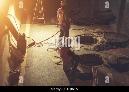 Worker working on the road at night time Stock Photo