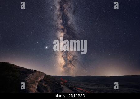 The Milky Way with car light trails on the Foreground Landscape Stock Photo