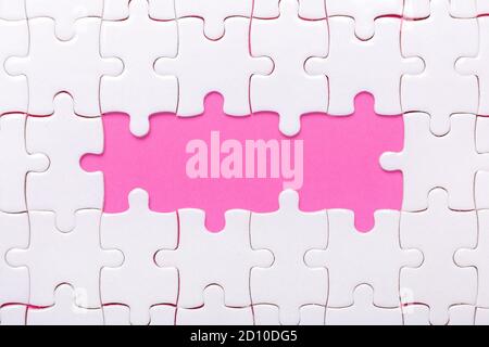 White jigsaw puzzle with empty space for text and pink background - Image Stock Photo