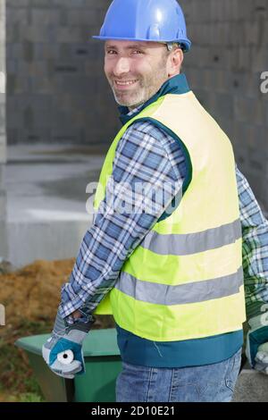 builder carrying blocks on a wheelbarrow at the construction site Stock Photo