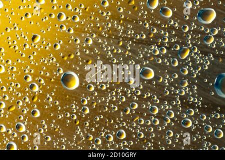 Droplets of sprayed water refracting the yellow light of a lemon, creating an abstract pattern. Stock Photo